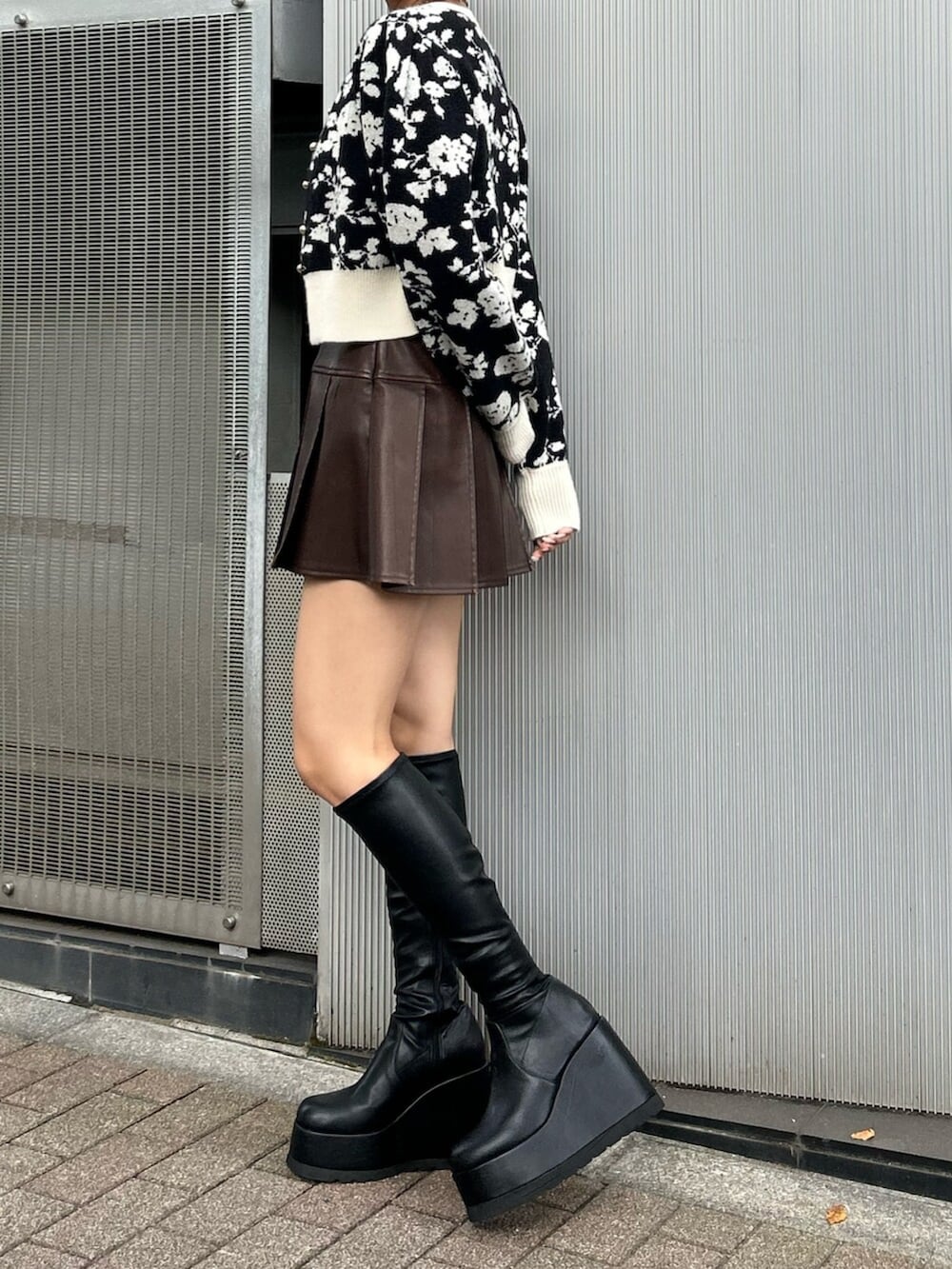 ブラック系のブーツ、ブラック系のニット/セーター、ブラウン系のスカートを着用したレディースの秋コーディネートの3枚目の写真