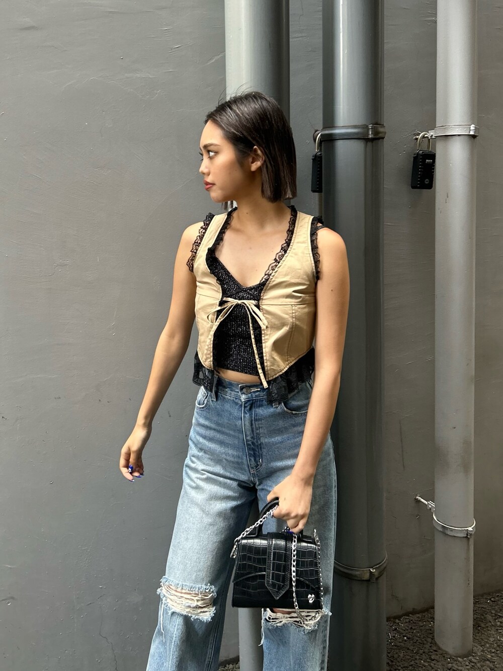 ブルー系のデニムパンツ、ブラック系のキャミソール、ベージュ系のシャツ/ブラウスを着用したレディースの春コーディネートの2枚目の写真