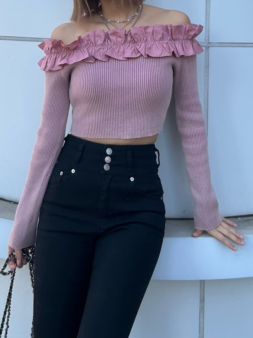 ブラック系のブーツ、ブラック系のデニムパンツ、ピンク系のニット/セーターを着用したレディースの冬コーディネートの4枚目の写真