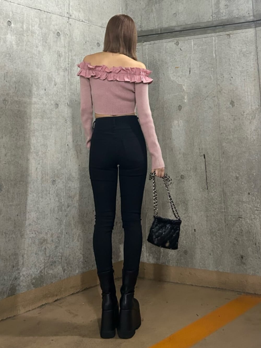 ブラック系のブーツ、ブラック系のデニムパンツ、ピンク系のニット/セーターを着用したレディースの冬コーディネートの3枚目の写真