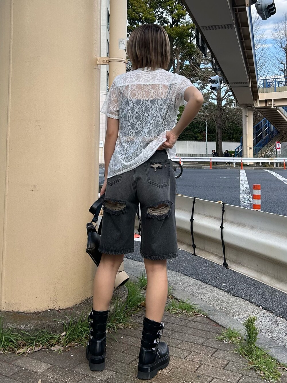 ブラック系のデニムパンツ、ホワイト系のシャツ/ブラウス、ブラック系のショルダーバッグを着用したレディースの春コーディネートの2枚目の写真