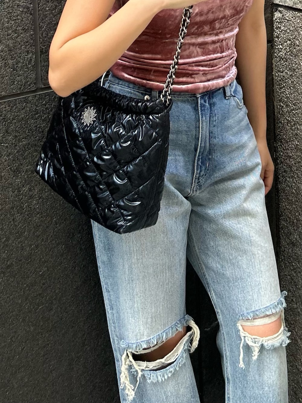 ブルー系のデニムパンツ、ピンク系のタンクトップ、ブラック系のサンダルを着用したレディースの春コーディネートの2枚目の写真