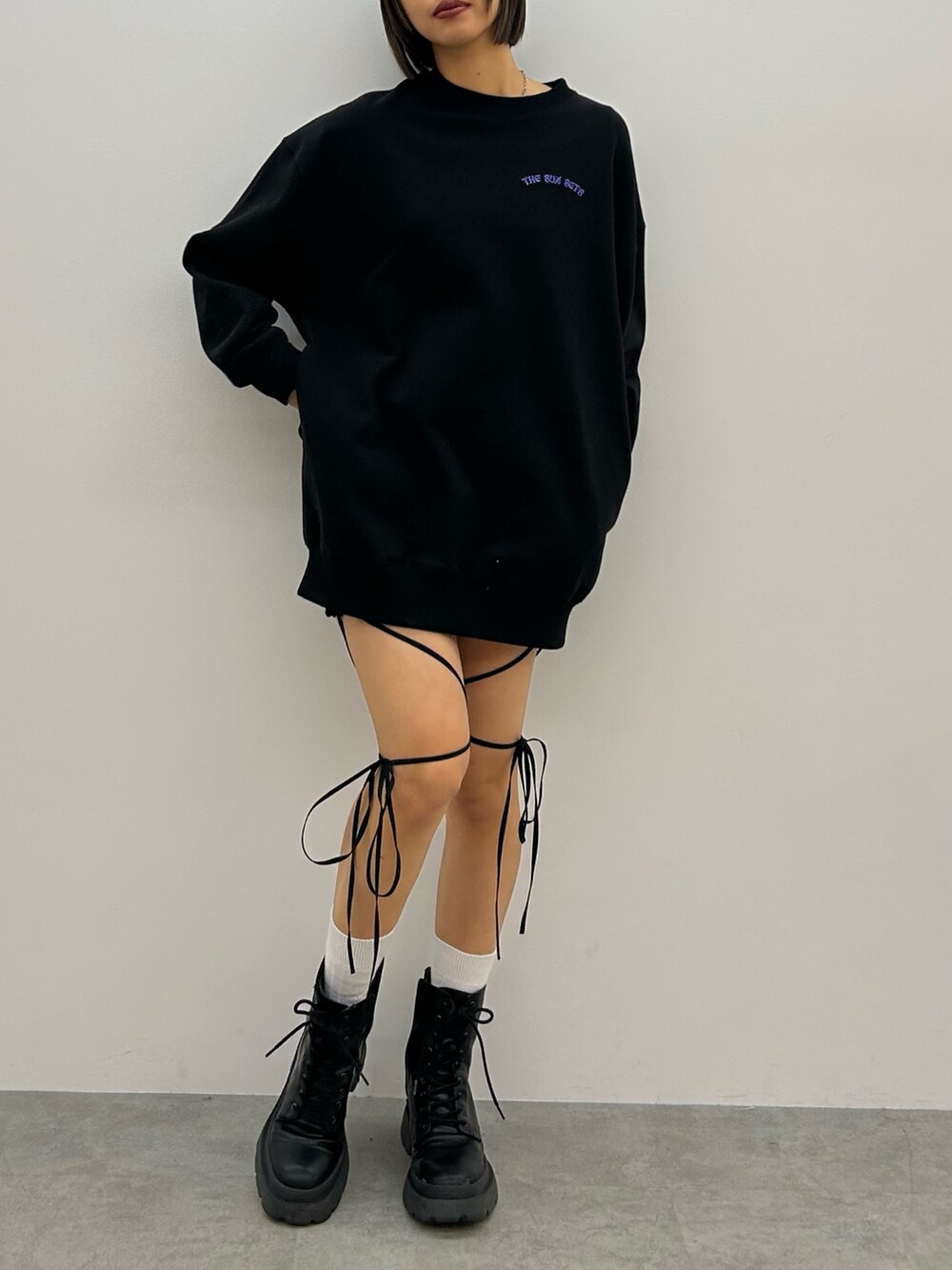 ブラック系のスウェット、ブラック系のその他パンツ、ブラック系のブーツを着用したレディースの冬コーディネートの2枚目の写真