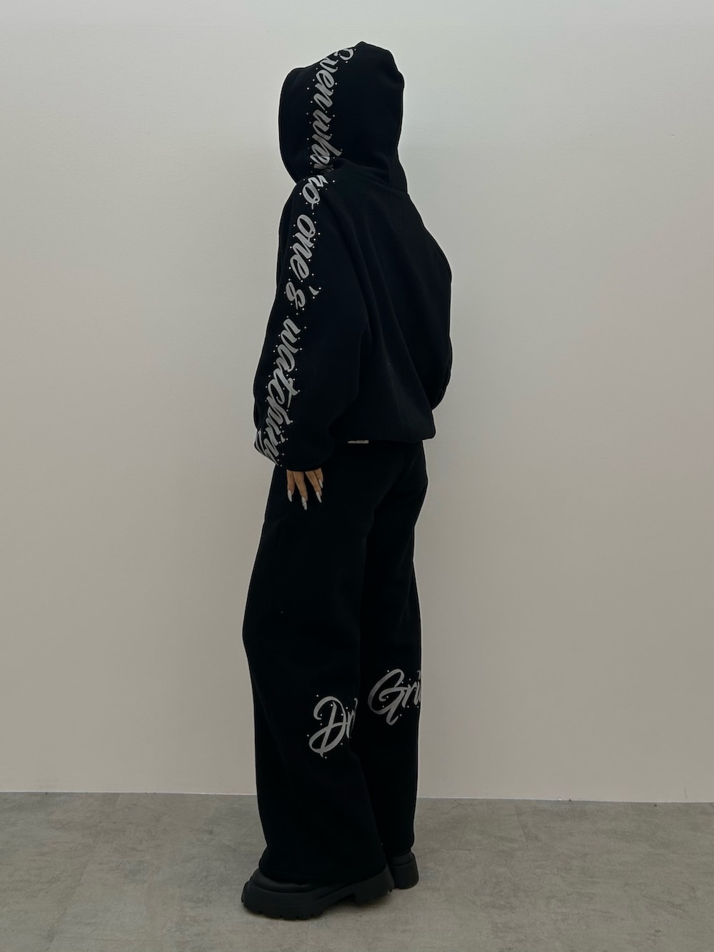 ブラック系のパーカー、ブラック系のブーツを着用したレディースの秋コーディネートの2枚目の写真