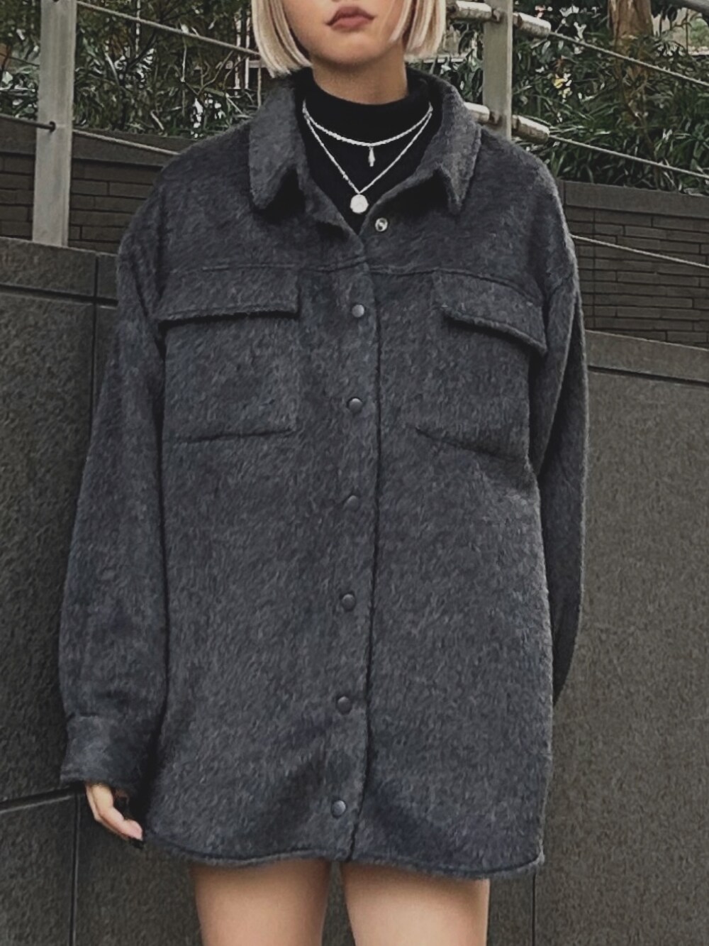 グレー系のミリタリージャケット、ブラック系のブーツ、ブラック系のニット/セーターを着用したレディースの秋コーディネートの2枚目の写真