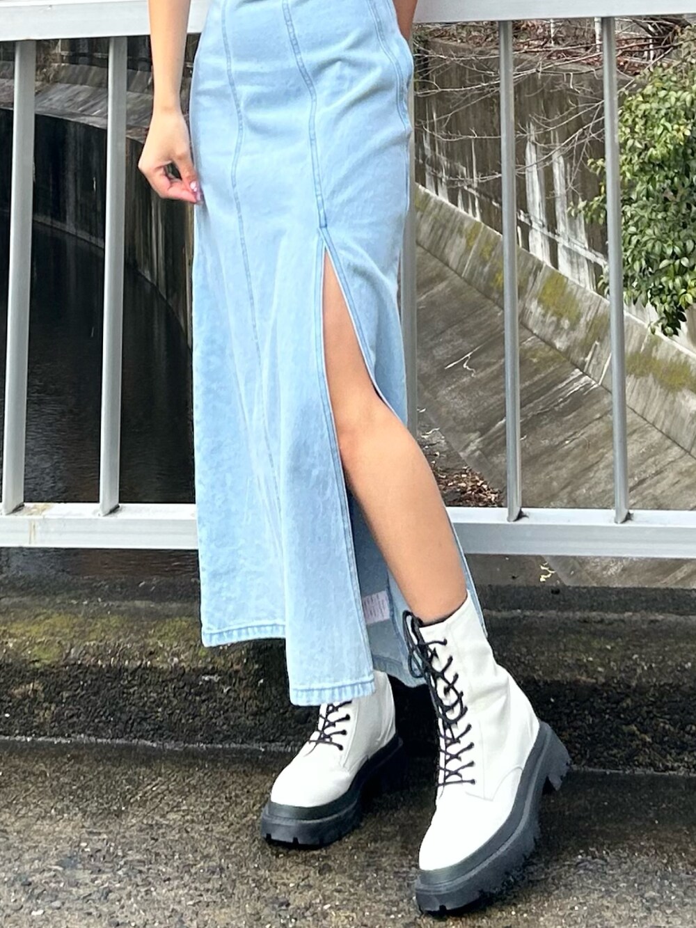 ブルー系のワンピース、ホワイト系のブーツを着用したレディースの春コーディネートの2枚目の写真