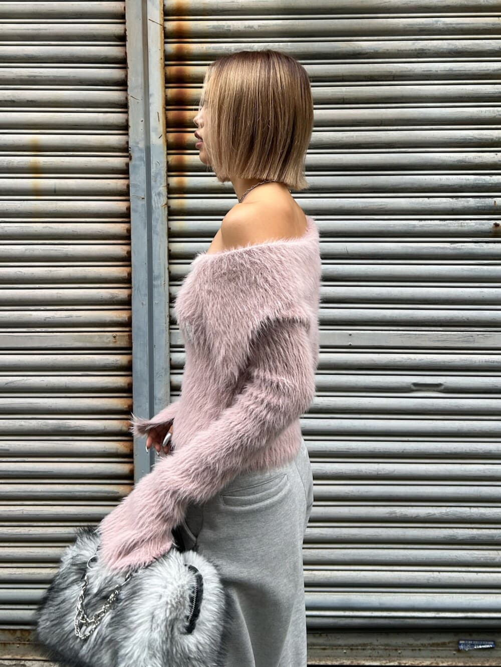 ブラック系のスリッポン、ピンク系のニット/セーター、グレー系のスウェットパンツを着用したレディースの秋コーディネートの5枚目の写真