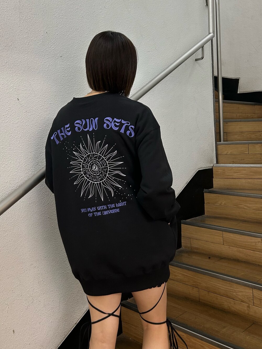 ブラック系のスウェット、ブラック系のその他パンツ、ブラック系のブーツを着用したレディースの冬コーディネートの3枚目の写真