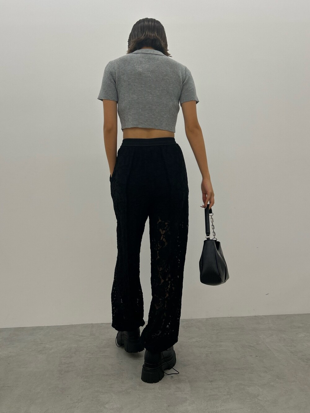 ブラック系のその他パンツ、グレー系のニット/セーター、ブラック系のハンドバッグを着用したレディースの夏コーディネートの2枚目の写真