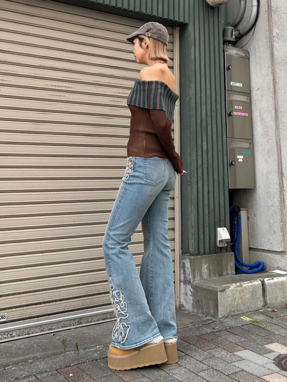 ブラウン系のニット/セーター、ベージュ系のスリッポン、ブルー系のデニムパンツを着用したレディースの秋コーディネートの3枚目の写真