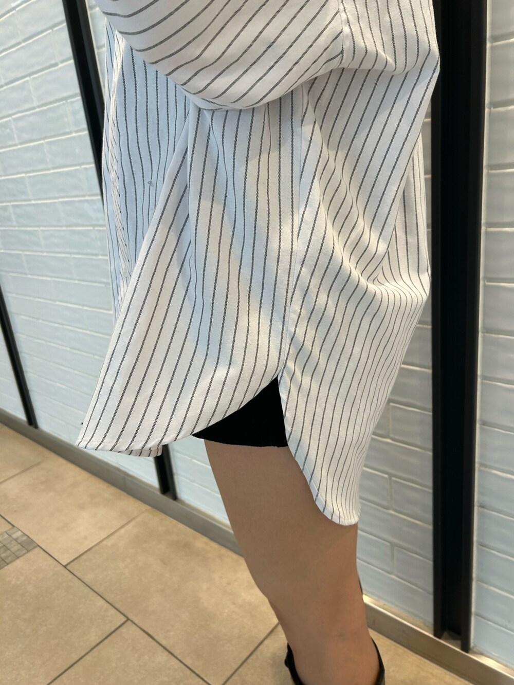 ホワイト系のシャツ/ブラウス、ブルー系のショルダーバッグ、ブラック系のブーツを着用したレディースの冬コーディネートの3枚目の写真