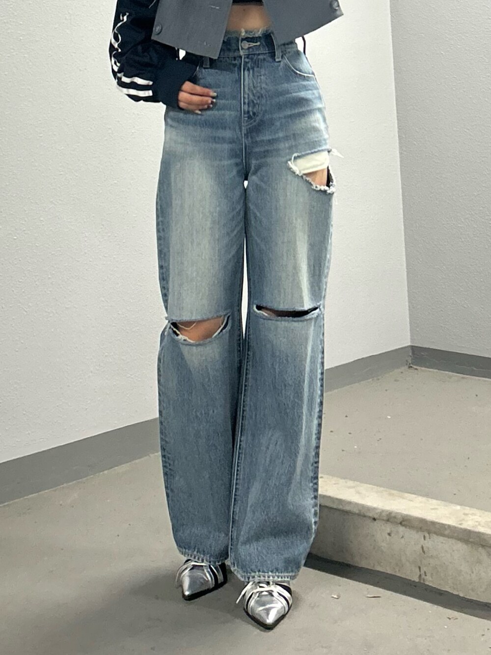 ブルー系のデニムパンツ、シルバー系のサンダル、グレー系のテーラードジャケットを着用したレディースの冬コーディネートの3枚目の写真