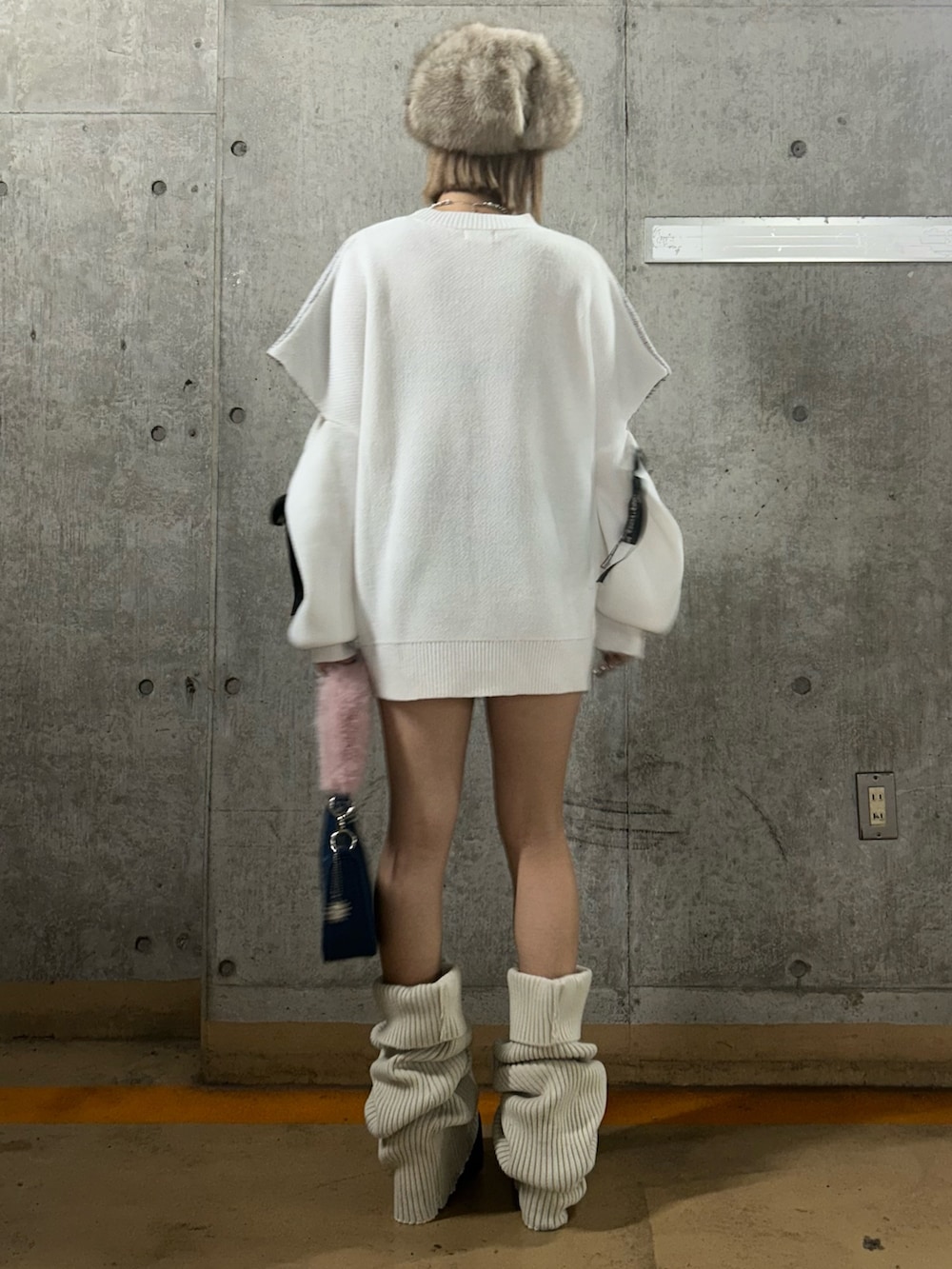 ホワイト系のニット/セーター、ブルー系のハンドバッグ、ブラウン系のブーツを着用したレディースの秋コーディネートの3枚目の写真