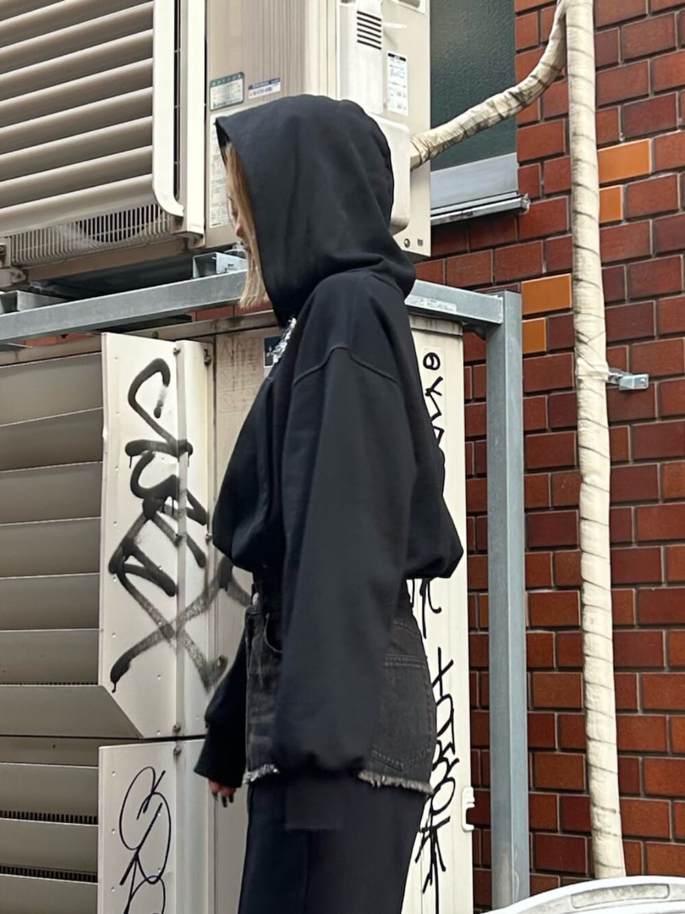 ブラック系のスリッポン、ブラック系のスウェットパンツ、ブラック系のパーカーを着用したレディースの秋コーディネートの5枚目の写真