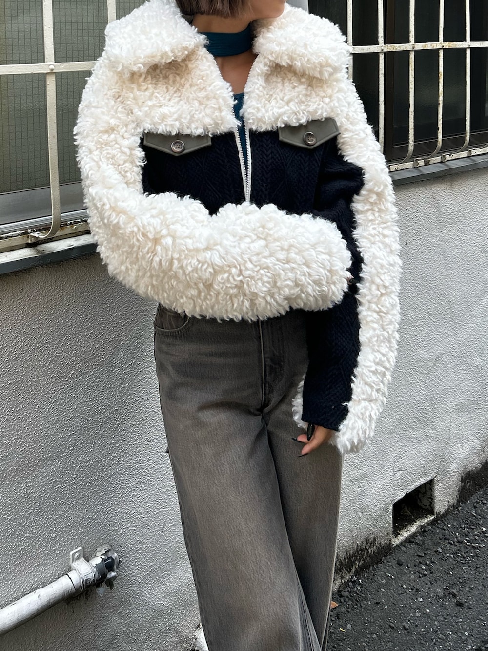 ブラック系のデニムパンツ、ホワイト系のブルゾン、ブルー系のTシャツ/カットソーを着用したレディースの秋コーディネートの3枚目の写真