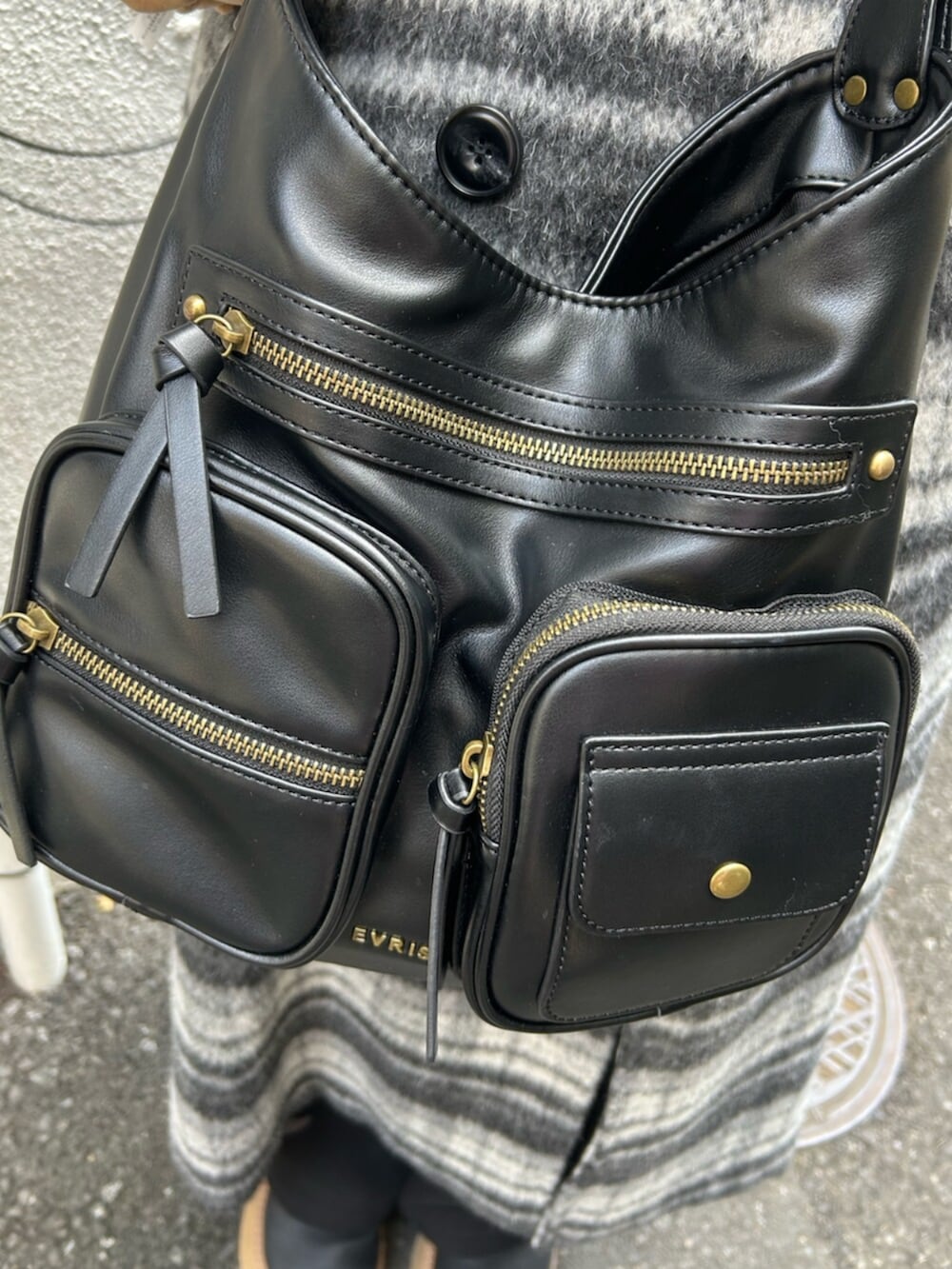 ブラック系のハンドバッグ、ブラック系のスリッポン、グレー系のチェスターコートを着用したレディースの秋コーディネートの9枚目の写真