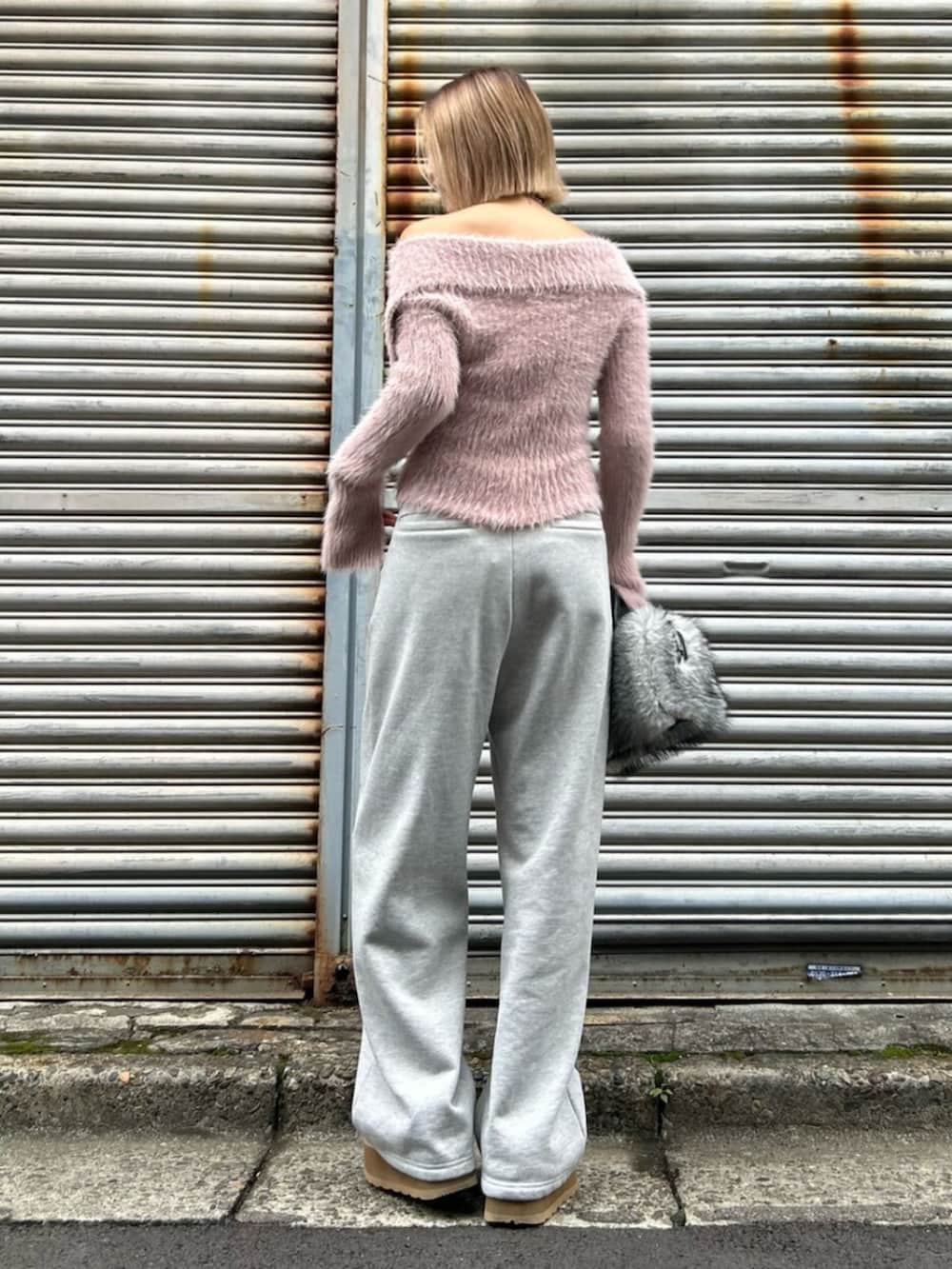 ブラック系のスリッポン、ピンク系のニット/セーター、グレー系のスウェットパンツを着用したレディースの秋コーディネートの3枚目の写真