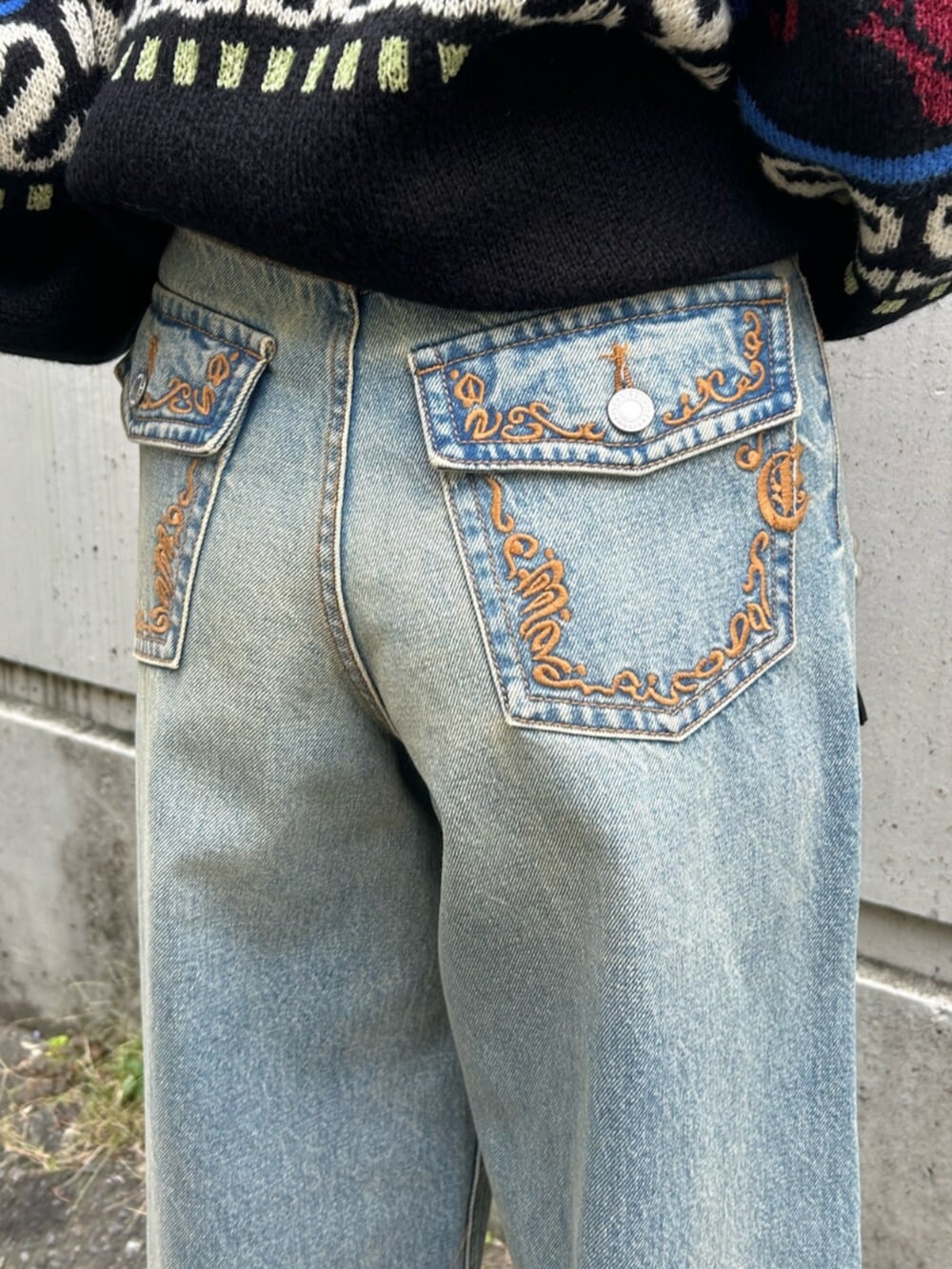 ブラック系のショルダーバッグ、ブラック系のニット/セーター、ブルー系のデニムパンツを着用したレディースの秋コーディネートの8枚目の写真