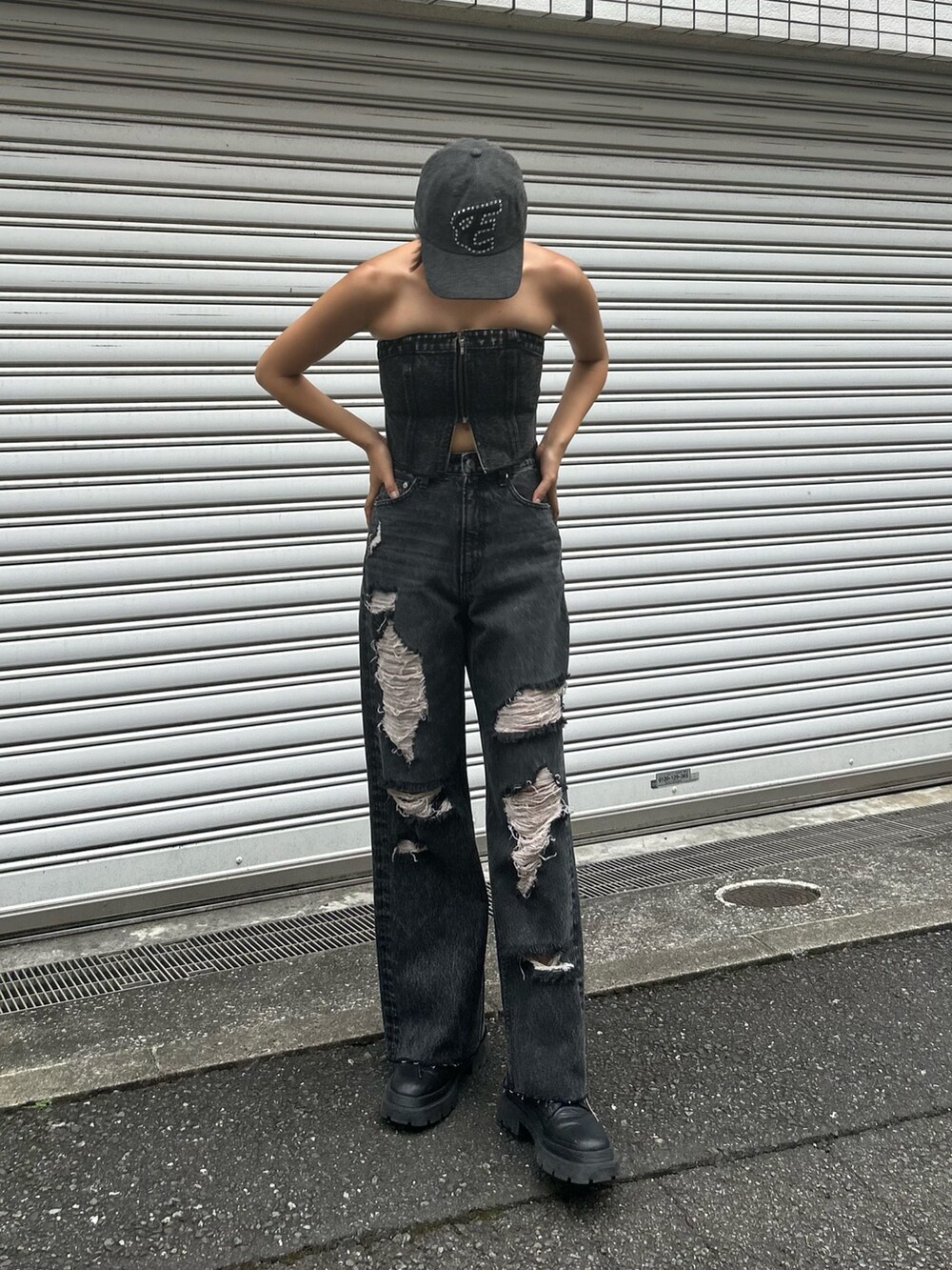 ブラック系のブーツ、ブラック系のデニムパンツ、ブラック系のキャミソールを着用したレディースの夏コーディネートの2枚目の写真