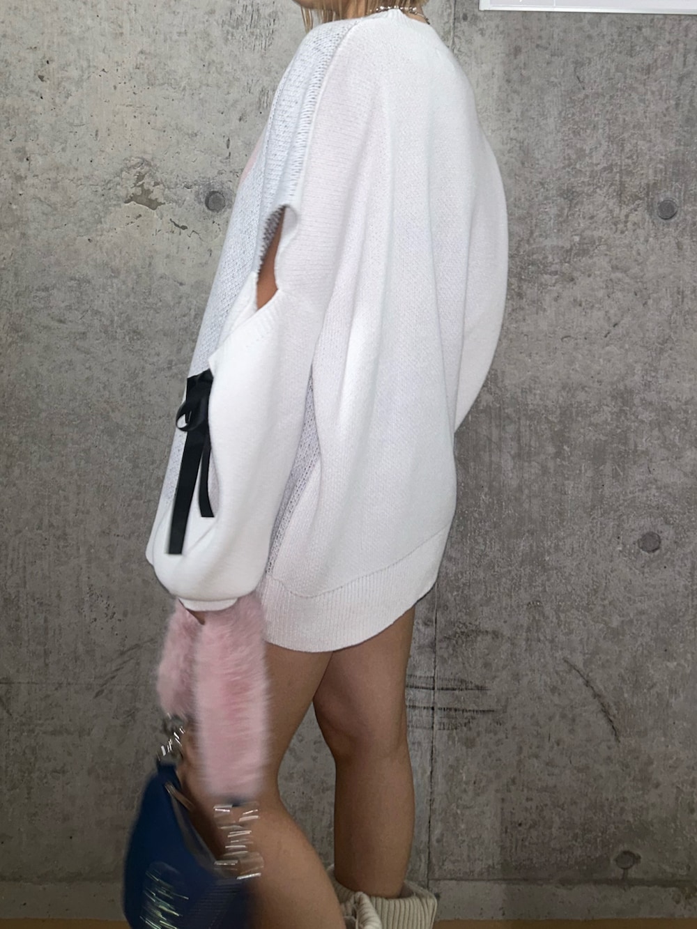 ホワイト系のニット/セーター、ブルー系のハンドバッグ、ブラウン系のブーツを着用したレディースの秋コーディネートの5枚目の写真