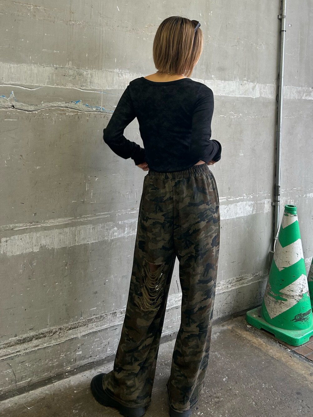 グリーン系のスウェットパンツ、ブラック系のTシャツ/カットソー、ブラック系のブーツを着用したレディースの春コーディネートの2枚目の写真