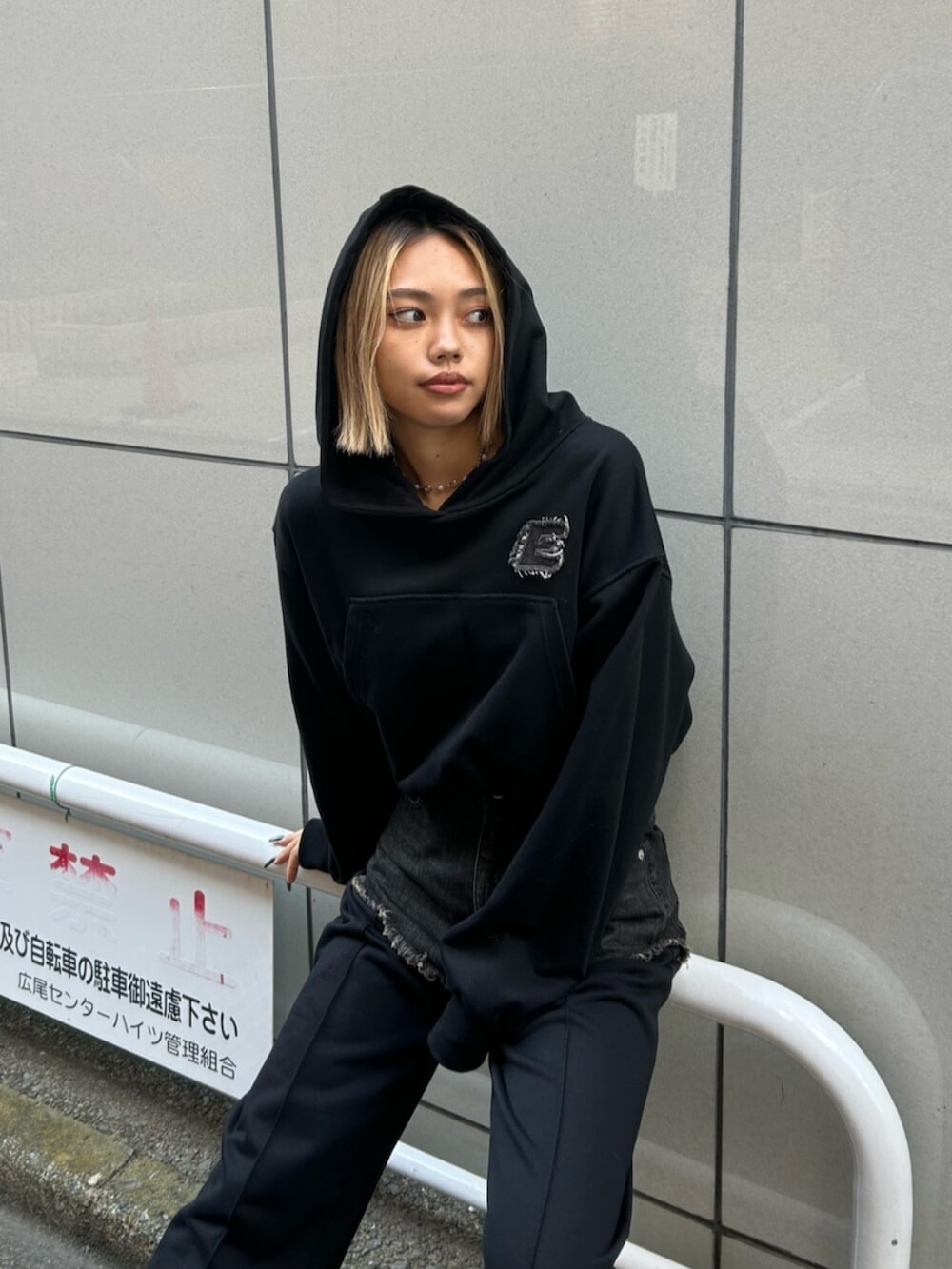 ブラック系のスリッポン、ブラック系のスウェットパンツ、ブラック系のパーカーを着用したレディースの秋コーディネートの4枚目の写真