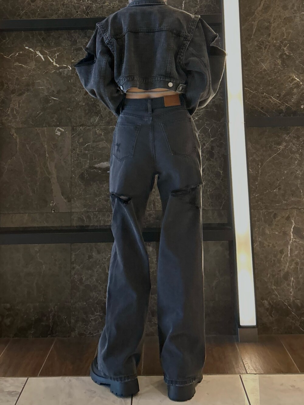 ブラック系のデニムジャケット、ブラック系のデニムパンツ、グレー系のTシャツ/カットソーを着用したレディースの秋コーディネートの3枚目の写真