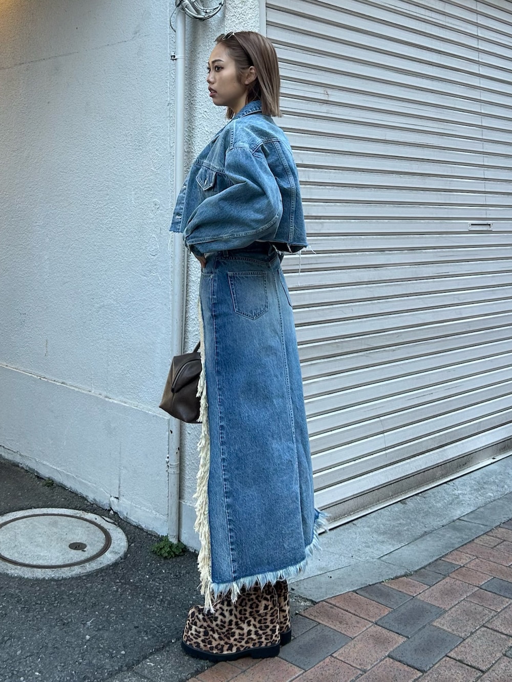 ブルー系のデニムスカート、ブルー系のデニムジャケット、ホワイト系のTシャツ/カットソーを着用したレディースの春コーディネートの2枚目の写真