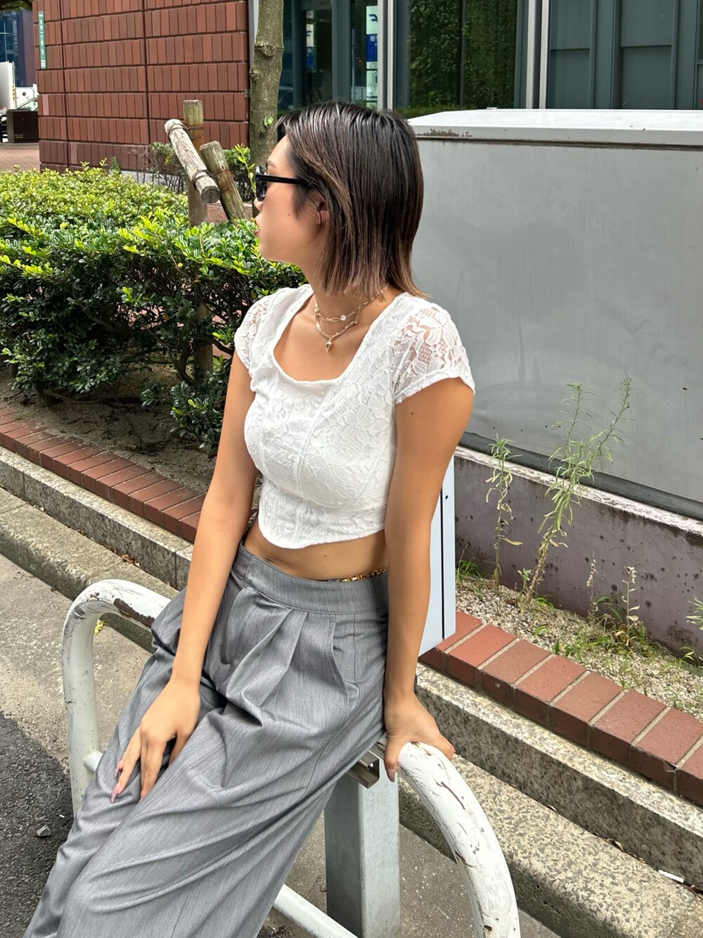 グレー系のその他パンツ、ホワイト系のTシャツ/カットソー、ブラック系のサンダルを着用したレディースの夏コーディネートの2枚目の写真