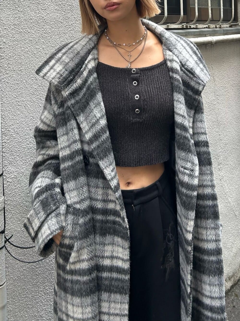 ブラック系のハンドバッグ、ブラック系のスリッポン、グレー系のチェスターコートを着用したレディースの秋コーディネートの4枚目の写真