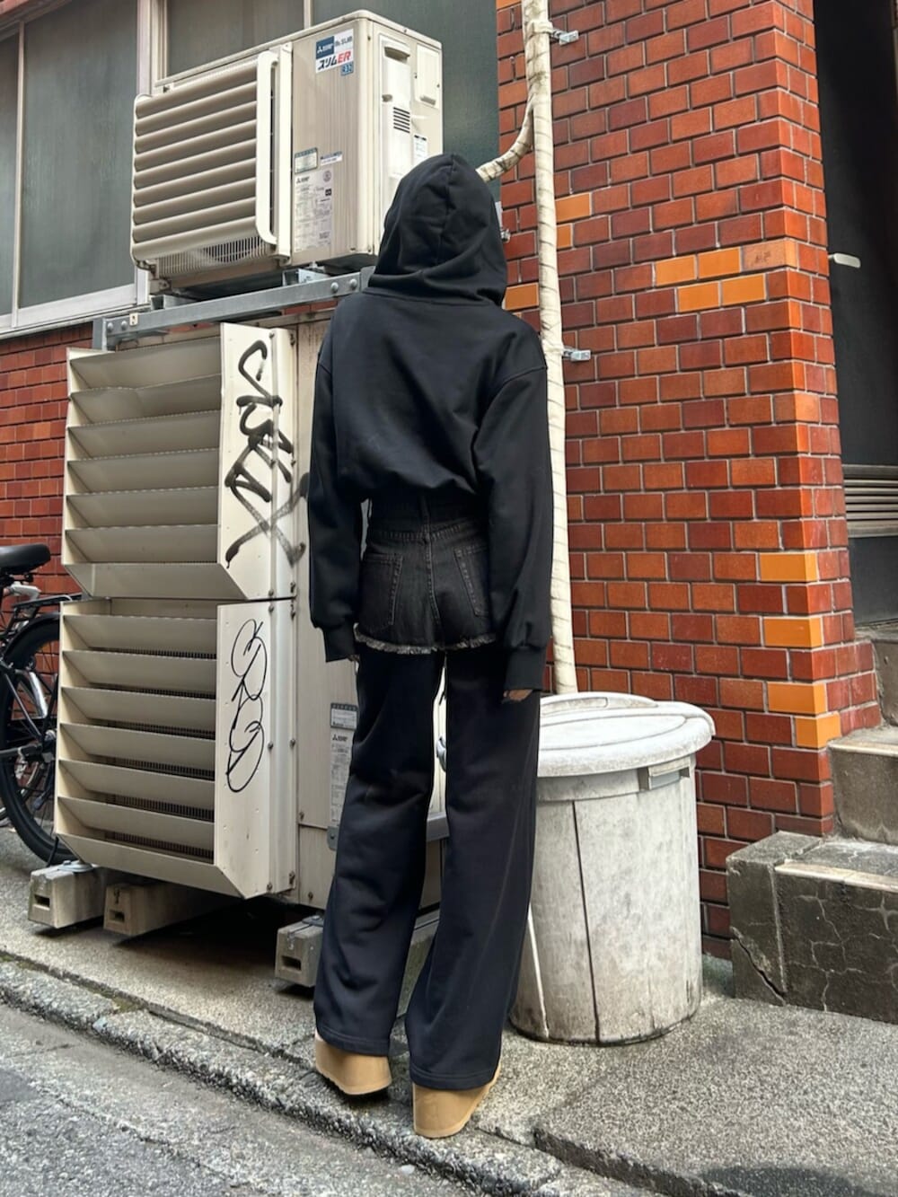 ブラック系のスリッポン、ブラック系のスウェットパンツ、ブラック系のパーカーを着用したレディースの秋コーディネートの3枚目の写真