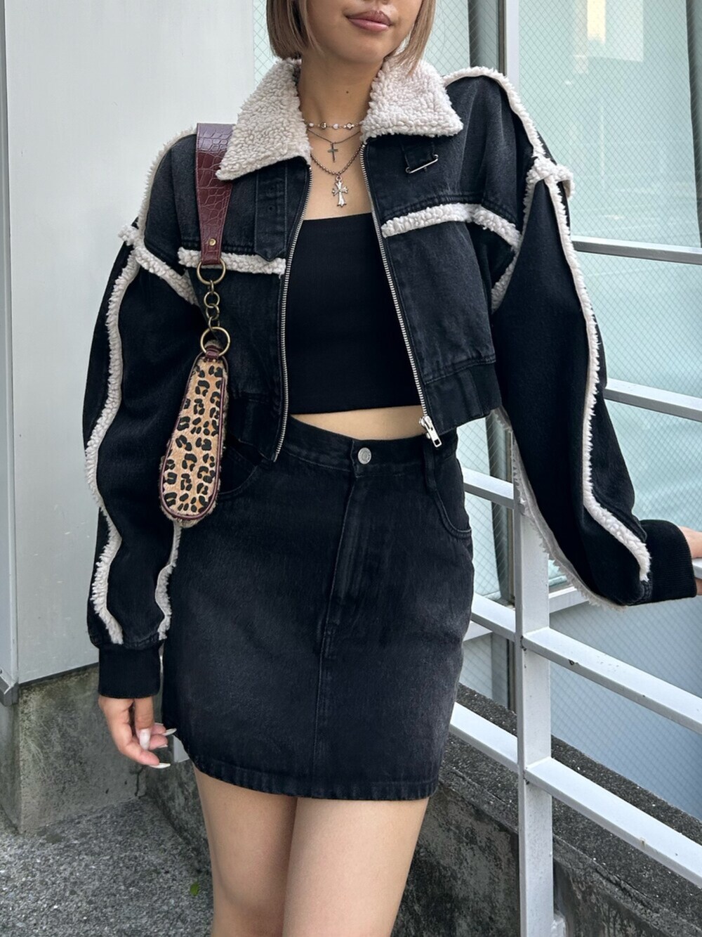 ブラック系のブルゾン、ブラック系のデニムスカート、ベージュ系のハンドバッグを着用したレディースの秋コーディネートの3枚目の写真