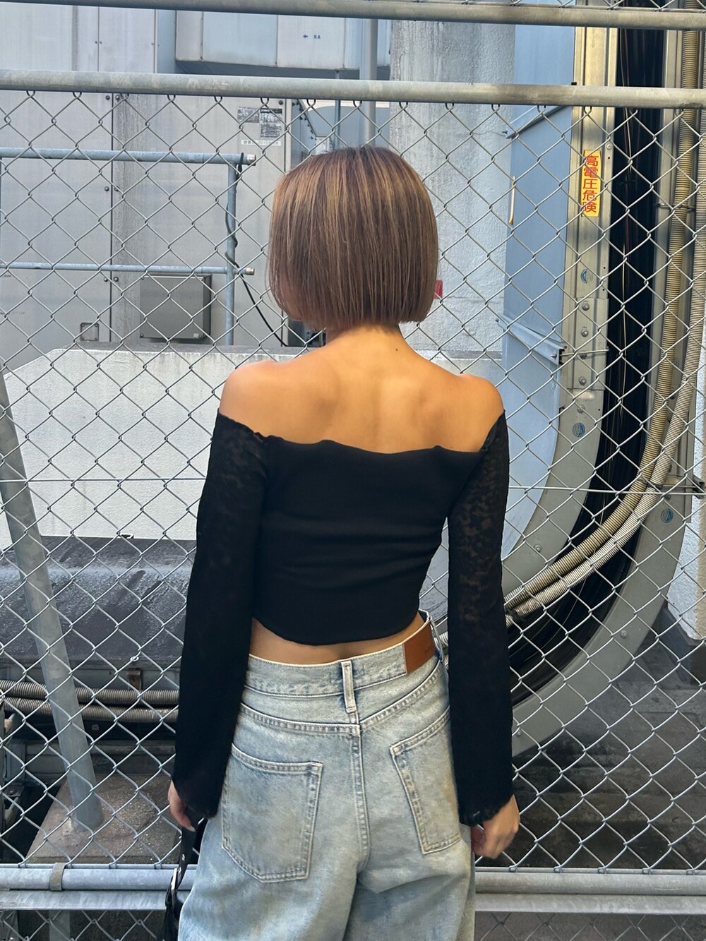 ブルー系のデニムパンツ、ブラック系のTシャツ/カットソー、ブラック系のブーツを着用したレディースの秋コーディネートの4枚目の写真