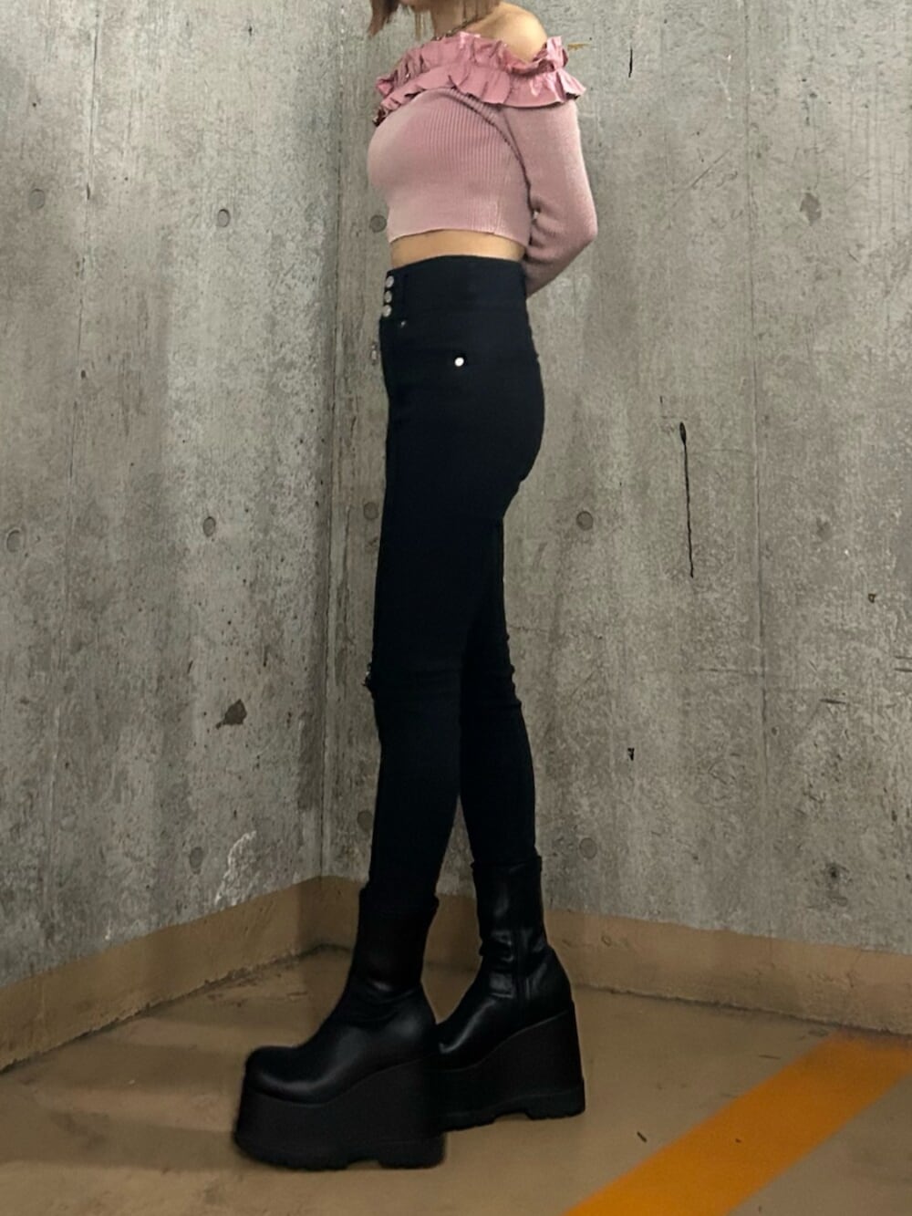 ブラック系のブーツ、ブラック系のデニムパンツ、ピンク系のニット/セーターを着用したレディースの冬コーディネートの2枚目の写真