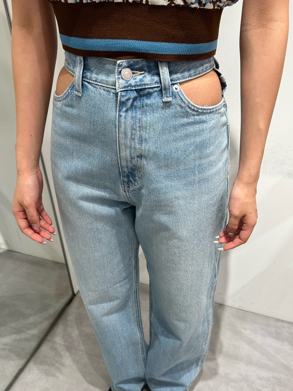 ブルー系のデニムパンツ、ブラウン系のニット/セーターを着用したレディースの春コーディネートの4枚目の写真