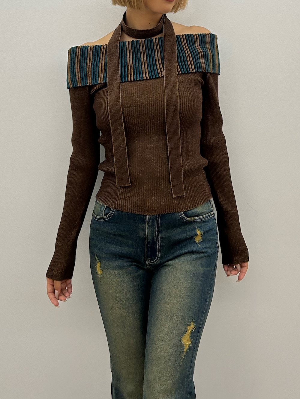 ブルー系のデニムパンツ、ブラウン系のニット/セーター、ブラック系のブーツを着用したレディースの夏コーディネートの4枚目の写真