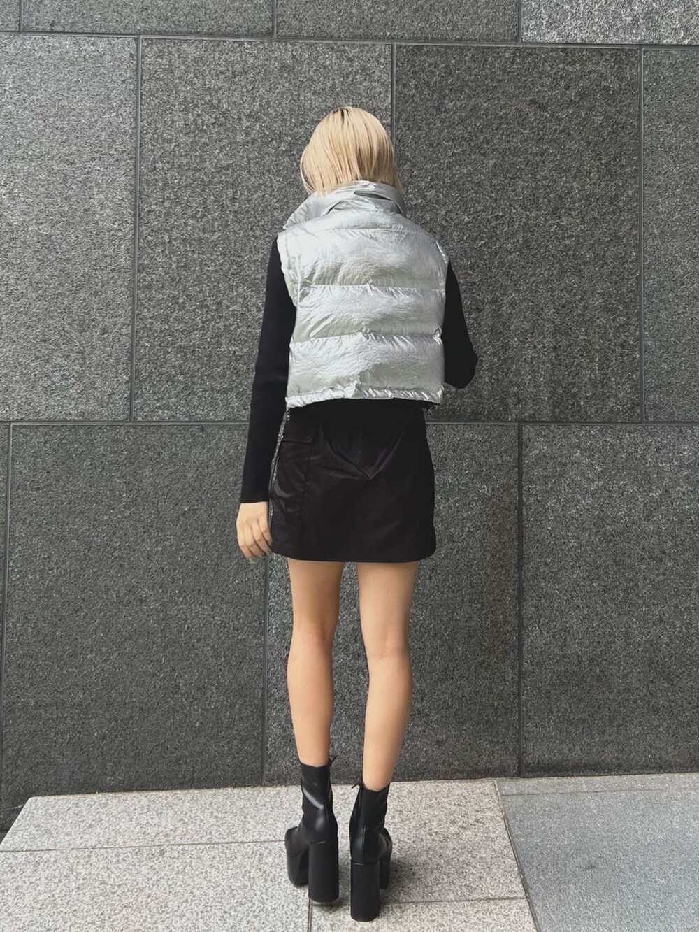 ブラック系のブーツ、ブラック系のスカート、ブラック系のニット/セーターを着用したレディースの秋コーディネートの2枚目の写真