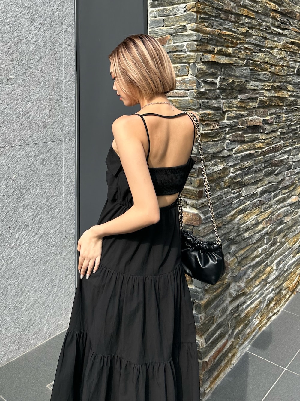 ブラック系のワンピース、ブラック系のショルダーバッグ、ブラック系のサンダルを着用したレディースの夏コーディネートの4枚目の写真