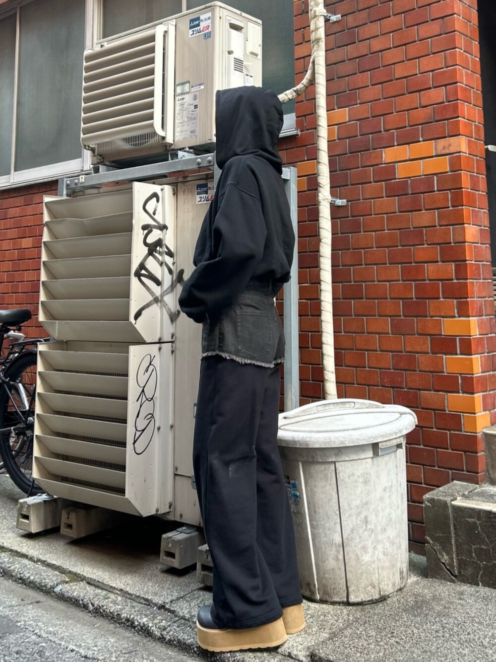 ブラック系のスリッポン、ブラック系のスウェットパンツ、ブラック系のパーカーを着用したレディースの秋コーディネートの2枚目の写真