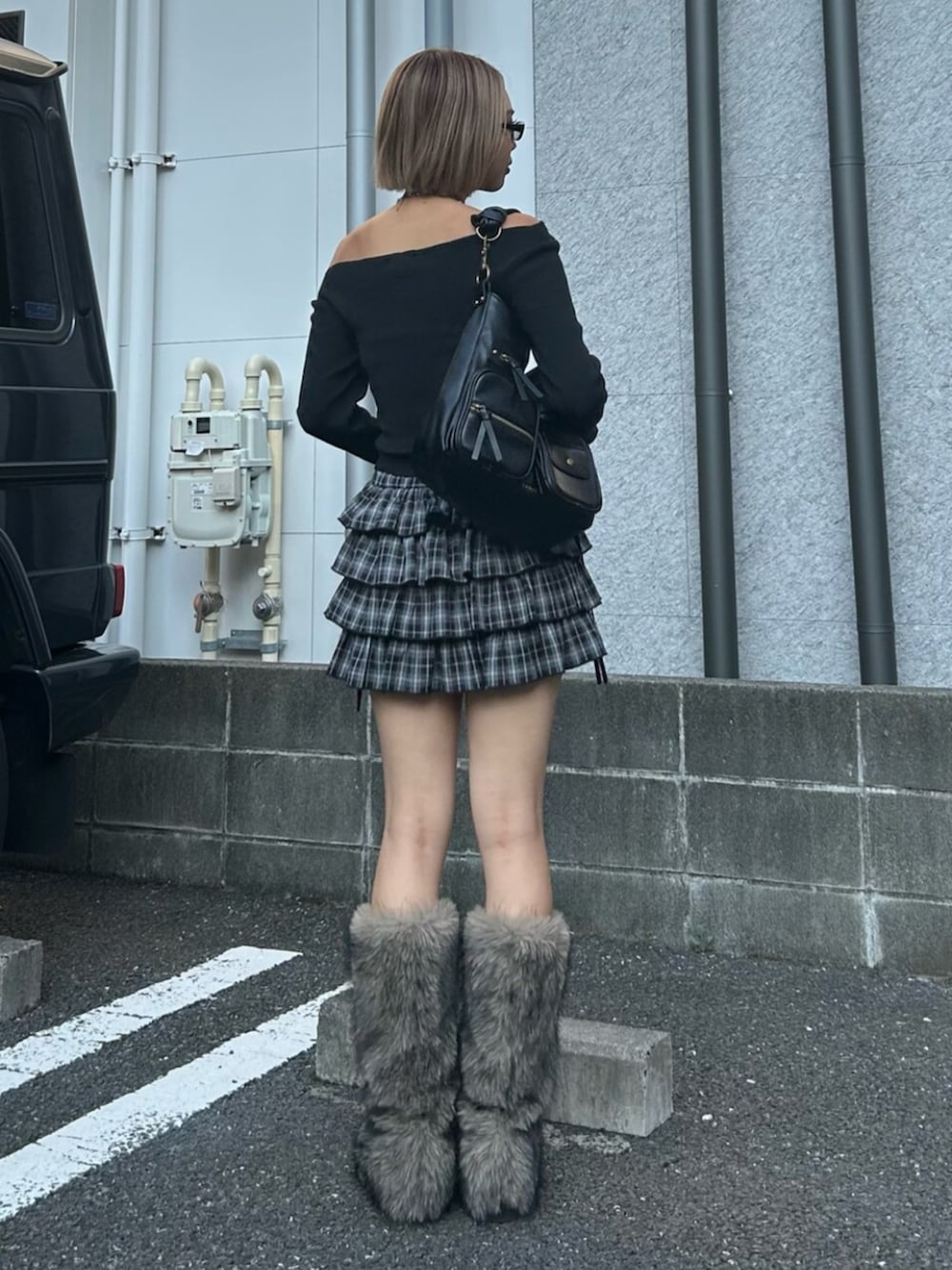 ブラック系のハンドバッグ、ブラック系のスカート、ブラック系のニット/セーターを着用したレディースの秋コーディネートの2枚目の写真