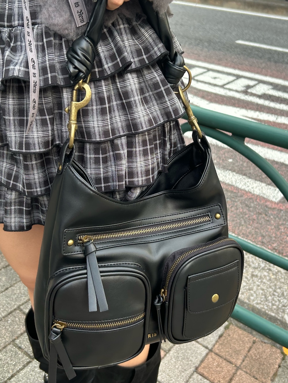 グレー系のニット/セーター、ブラック系のスカート、ブラック系のハンドバッグを着用したレディースの秋コーディネートの8枚目の写真