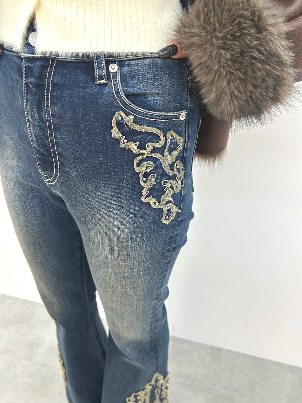 ブラウン系のブルゾン、ホワイト系のニット/セーター、ブルー系のデニムパンツを着用したレディースの秋コーディネートの9枚目の写真