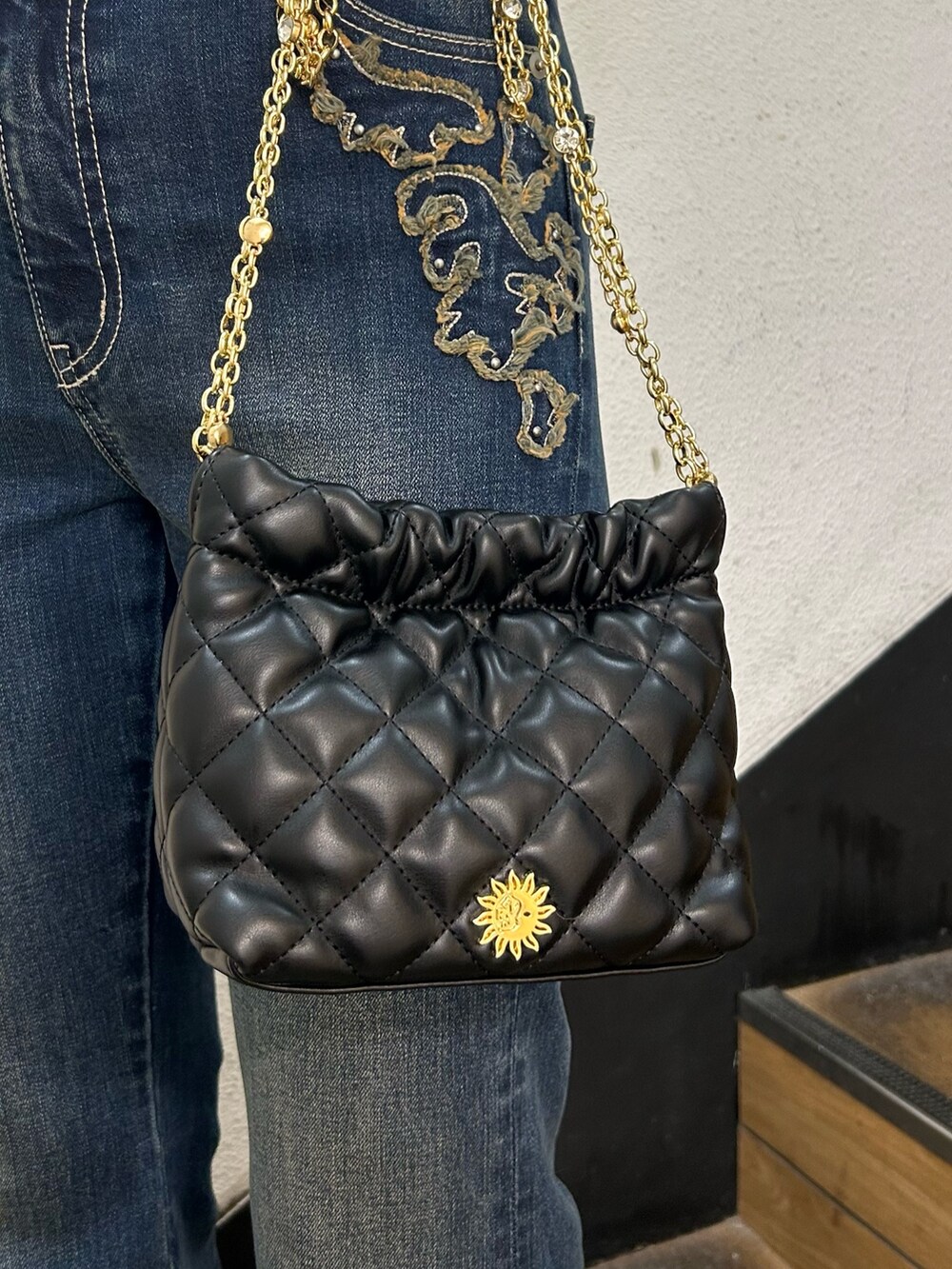 ホワイト系のニット/セーター、ブラック系のショルダーバッグ、ブルー系のデニムパンツを着用したレディースの秋コーディネートの9枚目の写真