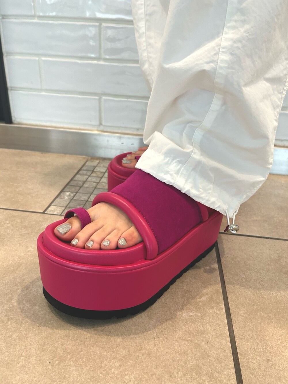 ホワイト系のカーゴパンツ、シルバー系のショルダーバッグ、グレー系のタンクトップを着用したレディースの夏コーディネートの5枚目の写真