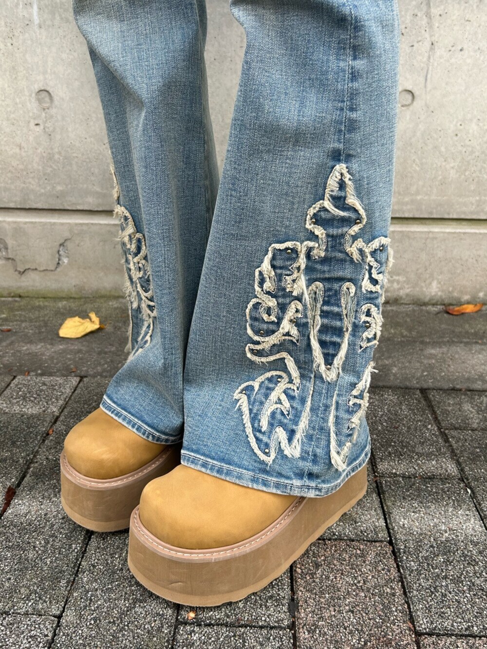 ブラウン系のニット/セーター、ベージュ系のスリッポン、ブルー系のデニムパンツを着用したレディースの秋コーディネートの9枚目の写真