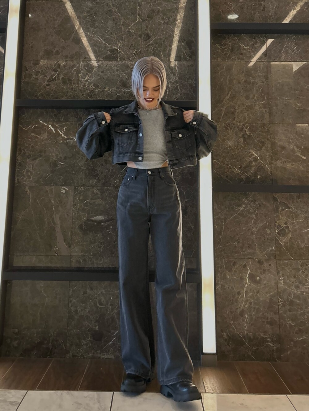 ブラック系のデニムジャケット、ブラック系のデニムパンツ、グレー系のTシャツ/カットソーを着用したレディースの秋コーディネートの2枚目の写真