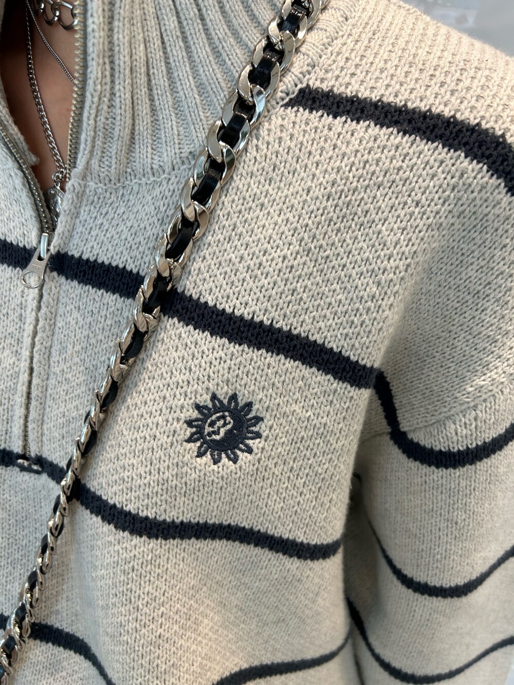 ブラック系のショルダーバッグ、ブラック系のスカート、ブラック系のブーツを着用したレディースの夏コーディネートの3枚目の写真