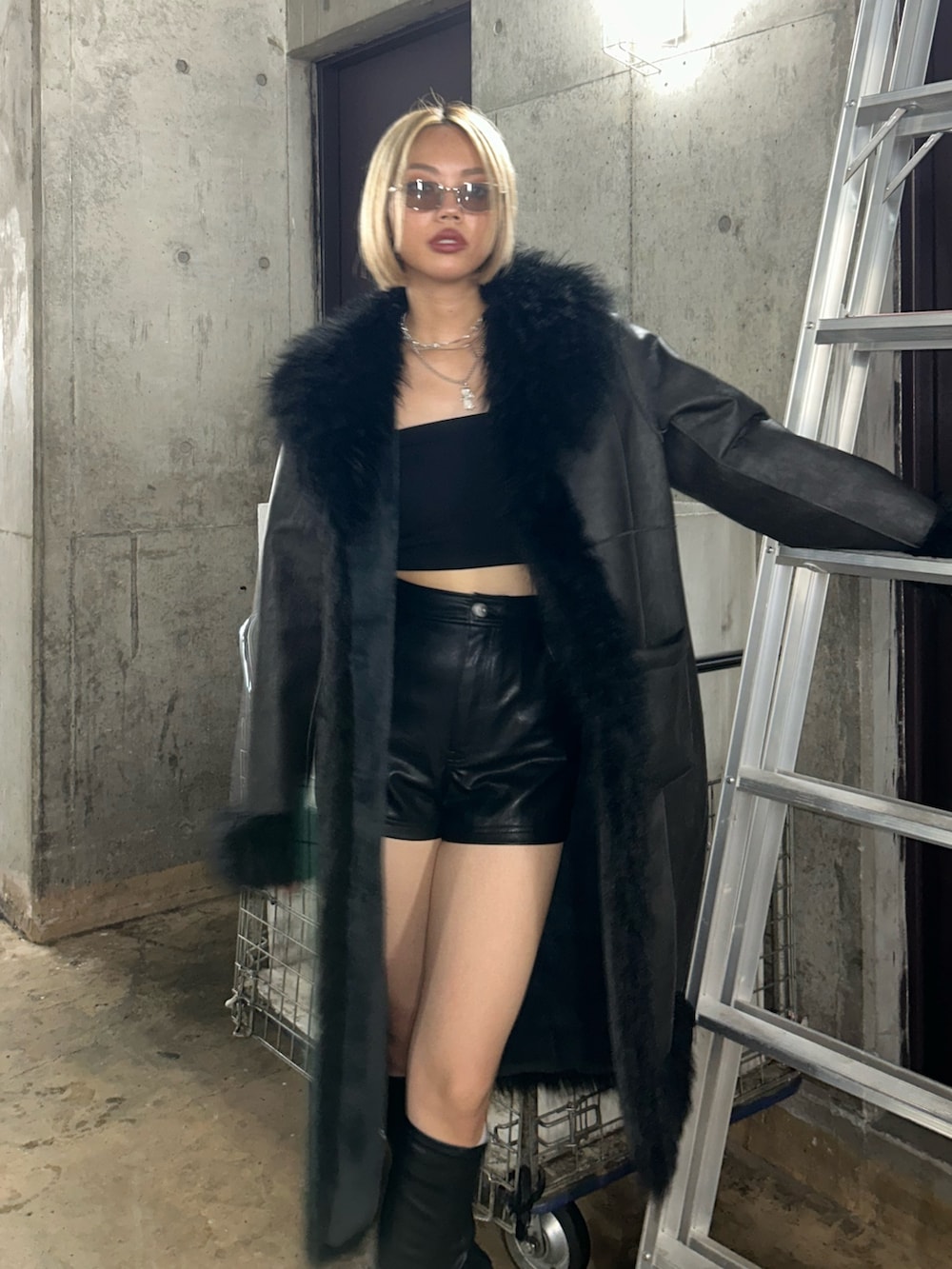 ブラック系のその他パンツ、ブラック系のムートンコート、ブラック系のブーツを着用したレディースの夏コーディネートの2枚目の写真