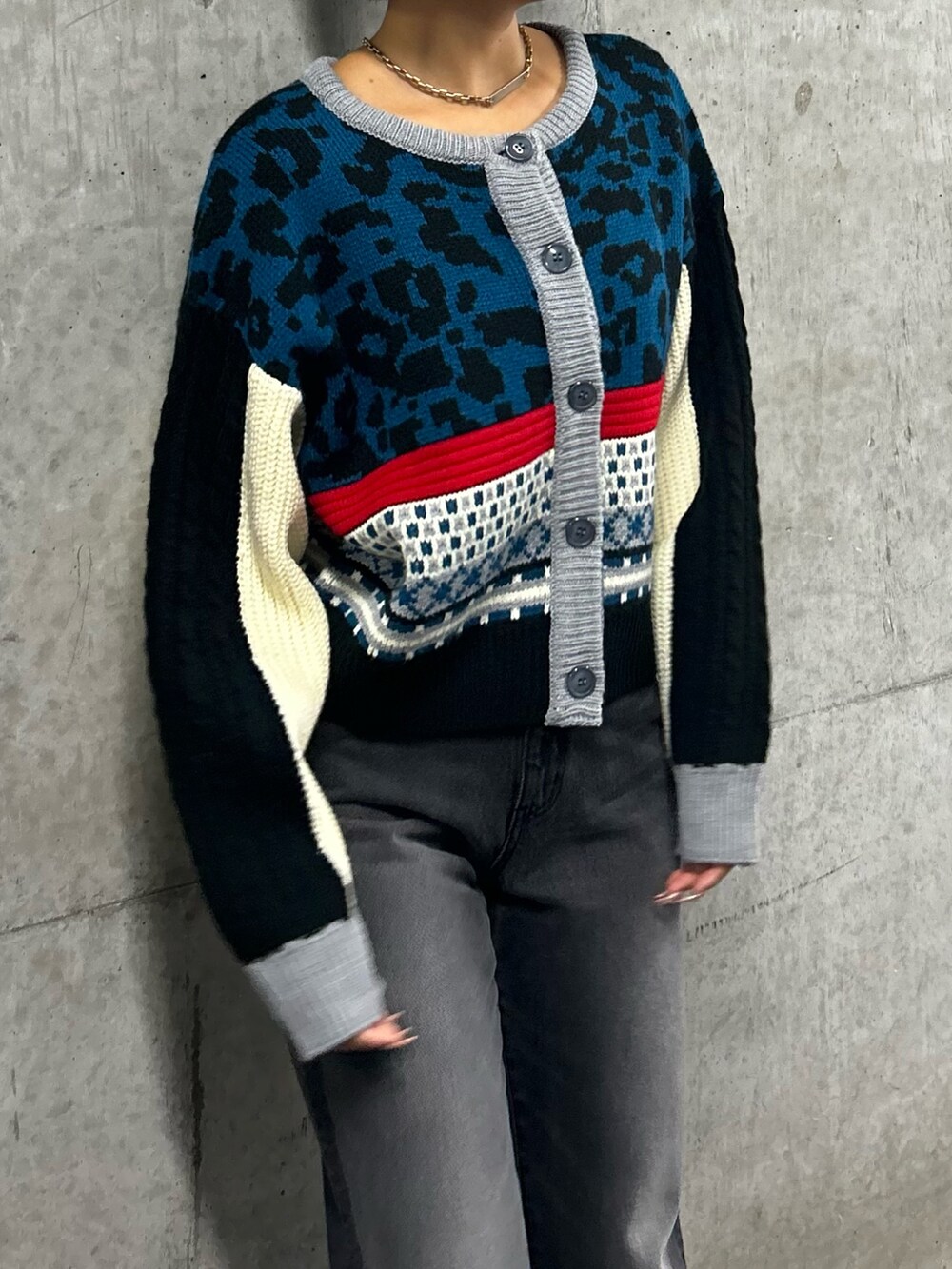 ブルー系のニット/セーター、ブラック系のデニムパンツ、ブラック系のローファーを着用したレディースの秋コーディネートの2枚目の写真