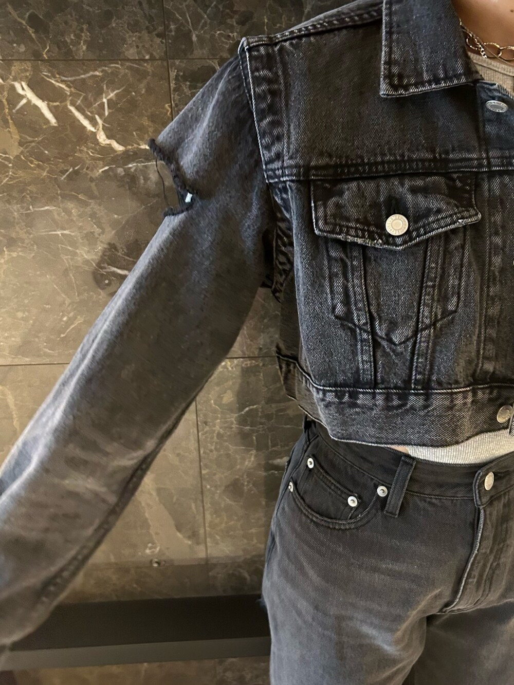 ブラック系のデニムジャケット、ブラック系のデニムパンツ、グレー系のTシャツ/カットソーを着用したレディースの秋コーディネートの5枚目の写真